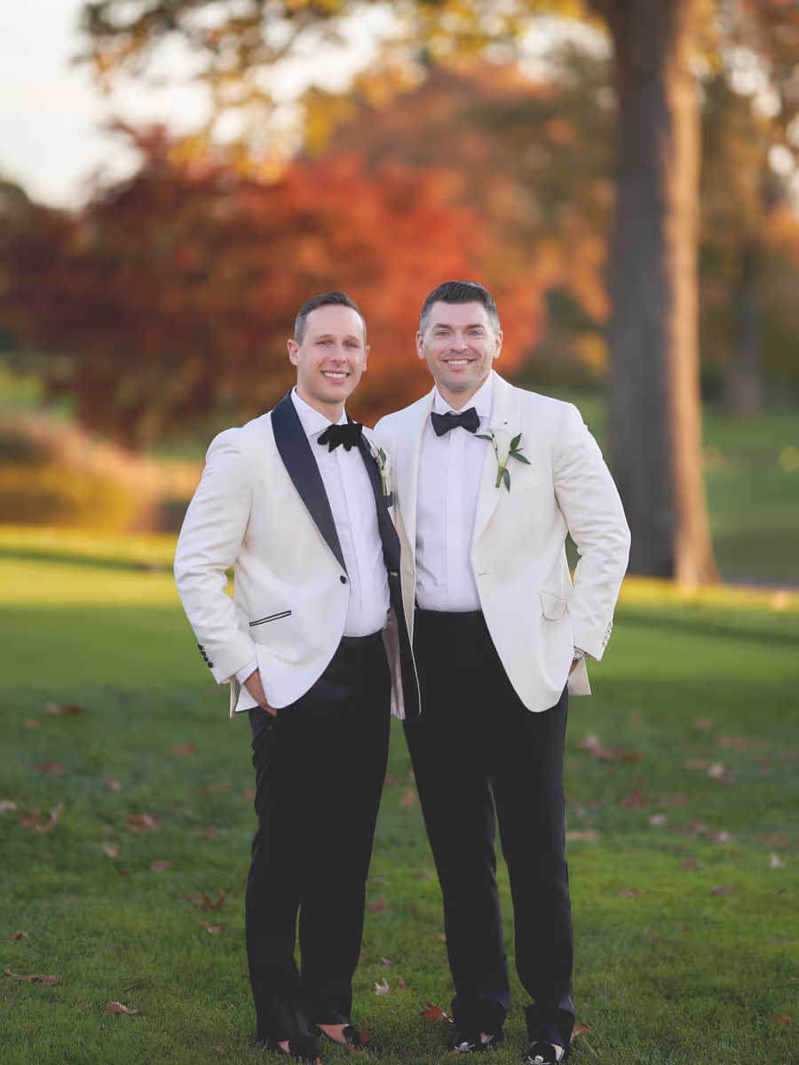 Wedding portrait in white dinner jackets against autumn color at golden hour