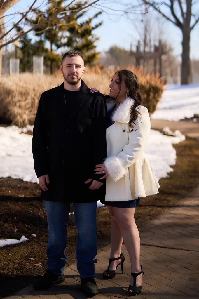 Couple by a lake on a clear winter day, the bride in a white coat