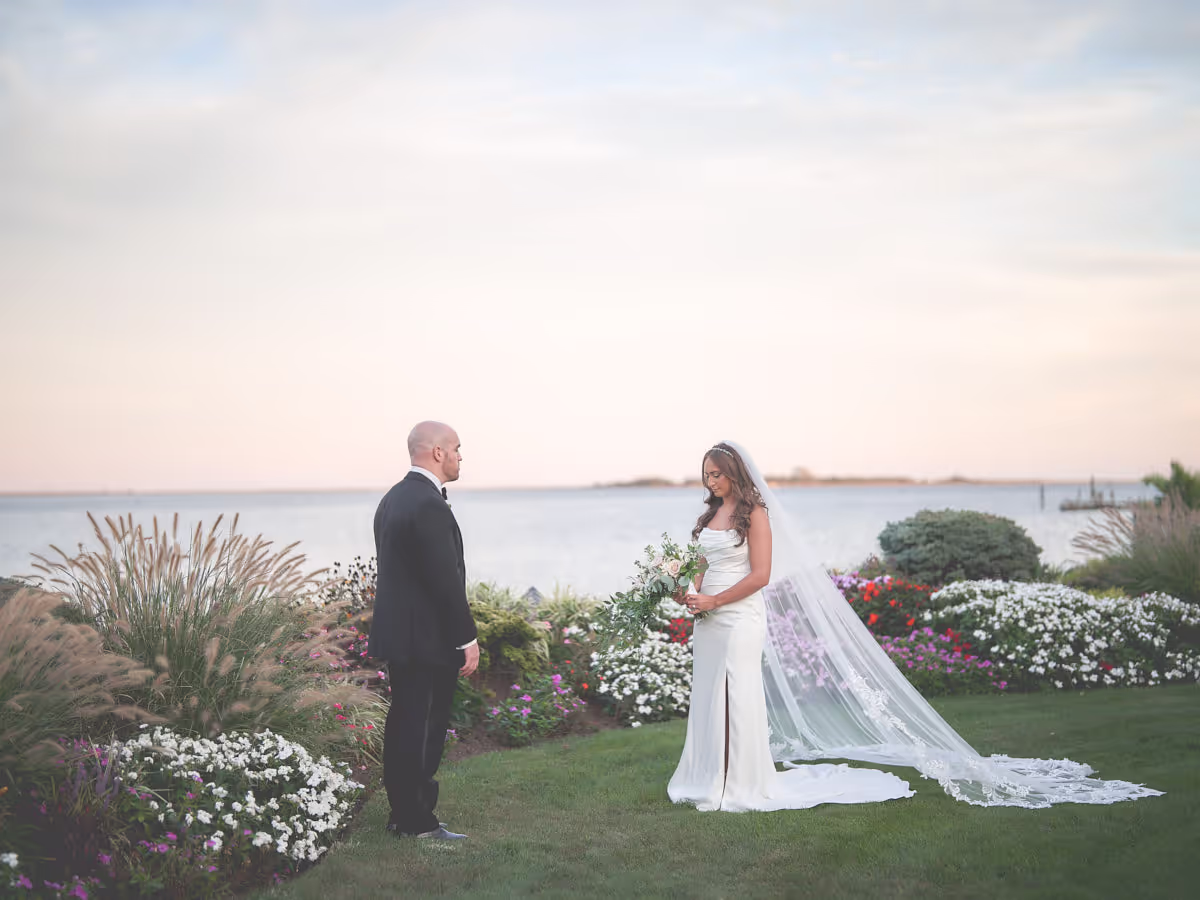 Watermill Caterers, Smithtown, Bride and groom share a first look on a waterfront lawn at golden hour