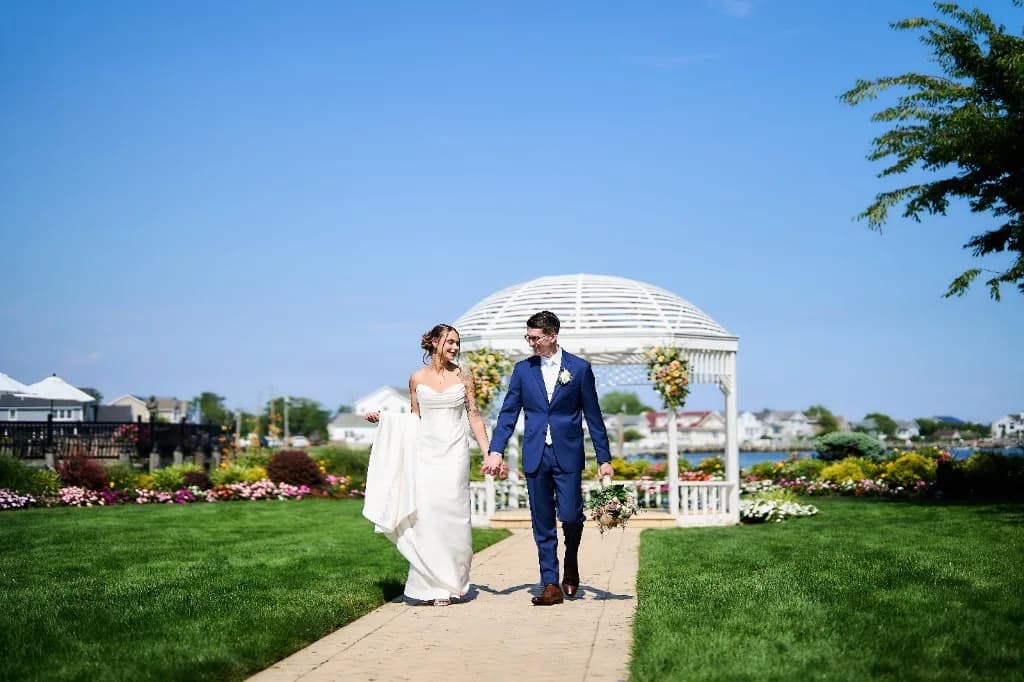 Melanie and Matthew walking the path toward the gazebo, holding hands