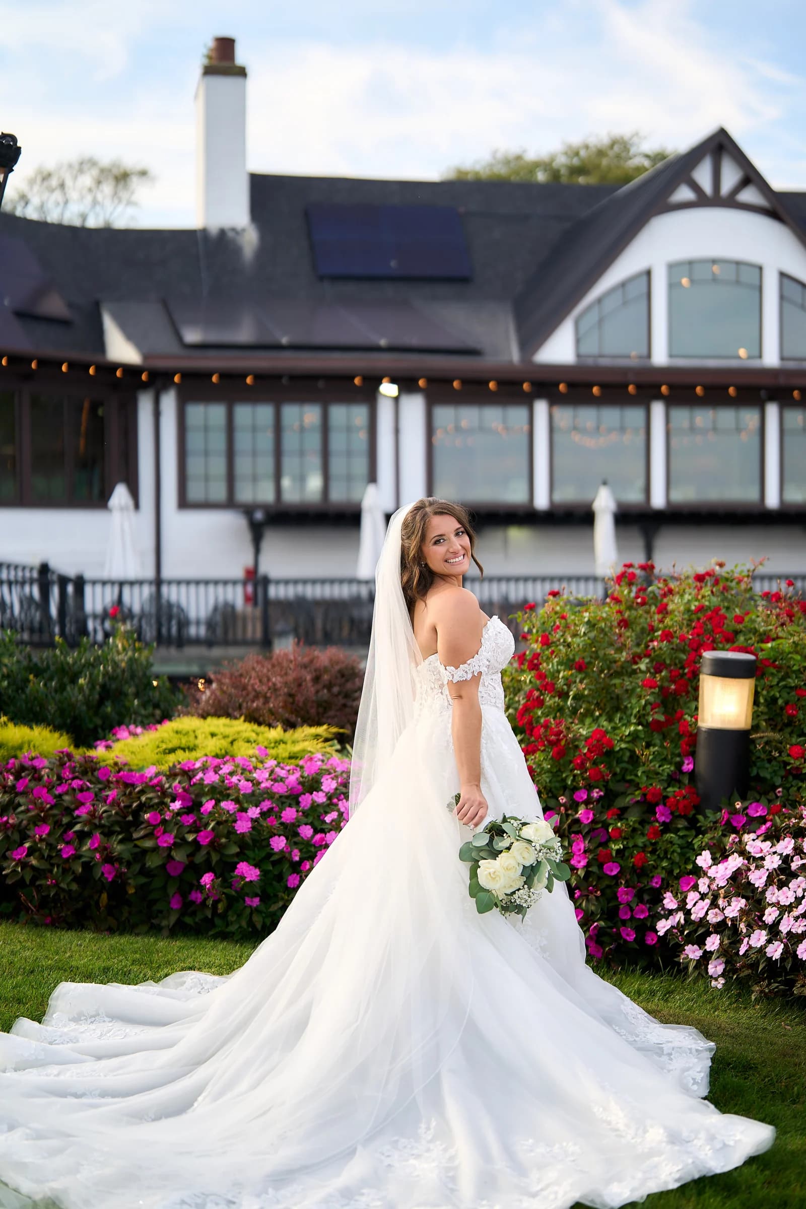 Amanda looking back over her shoulder, her train spread across the grass at the Riviera