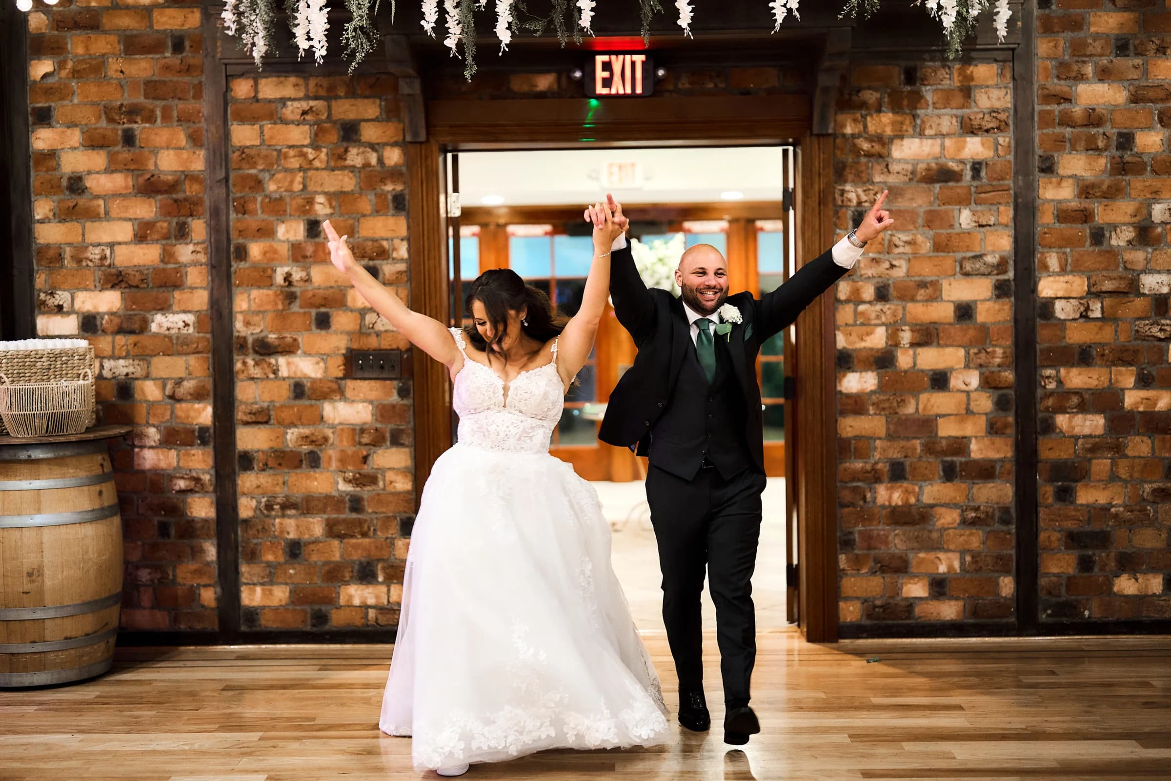 Amanda and Gabriele entering the reception with their arms raised