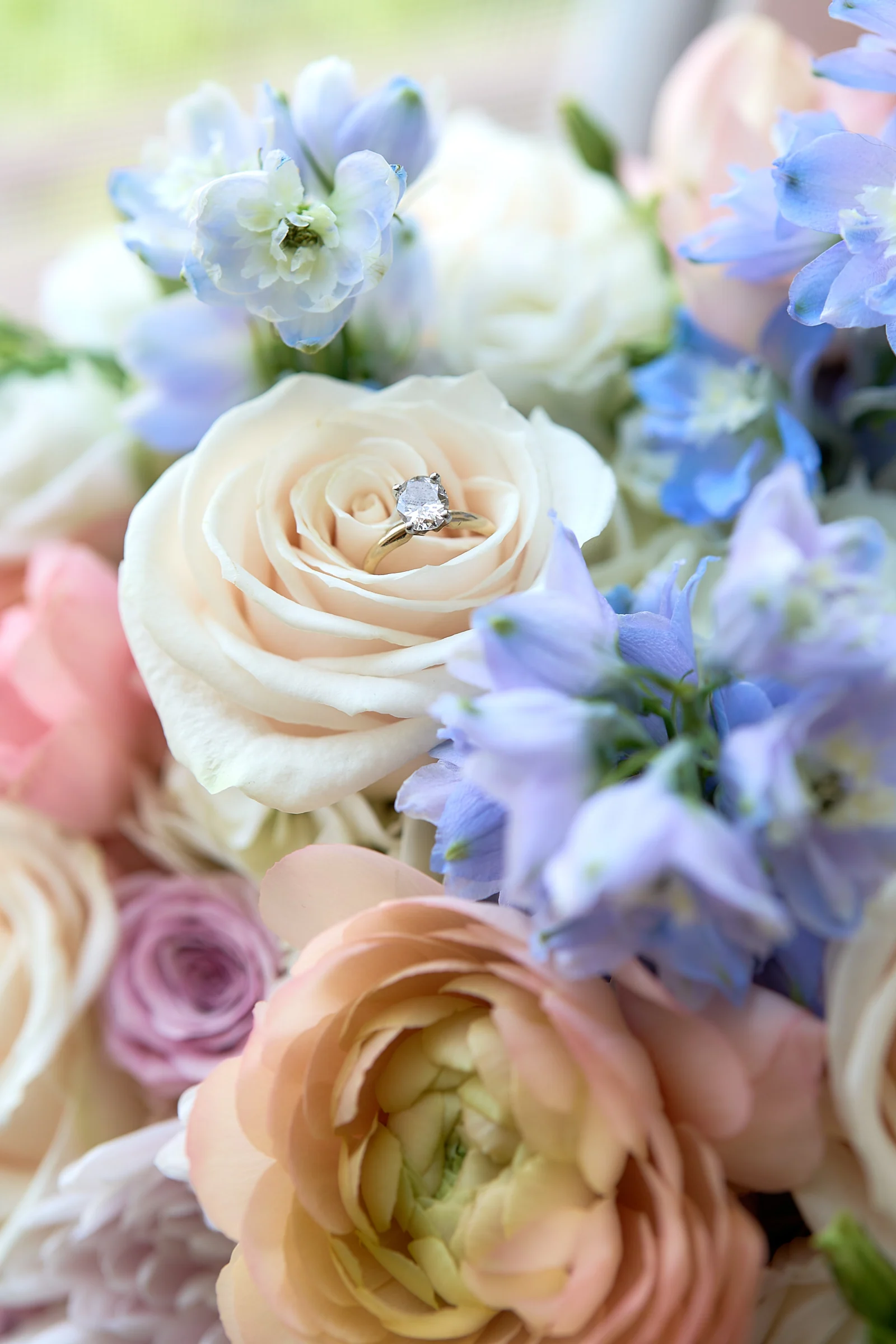 Diamond engagement ring resting in a white rose in Gabriela and Jakub's bouquet