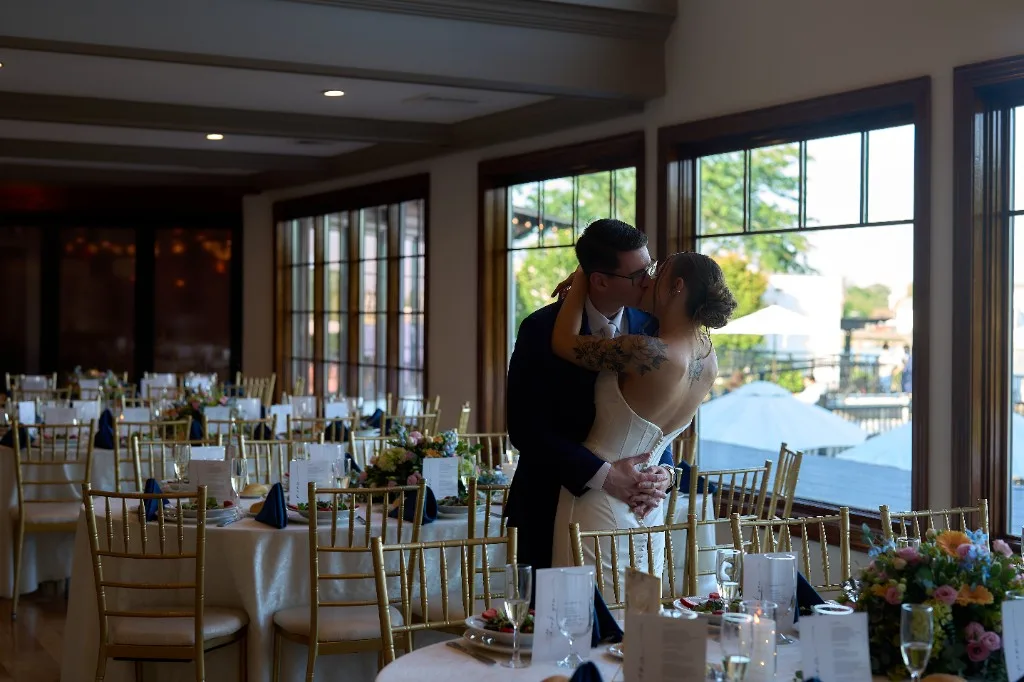 The Garden City Hotel, Garden City, Bride and groom in the ballroom with string lights and a candlelit fireplace at the Riviera