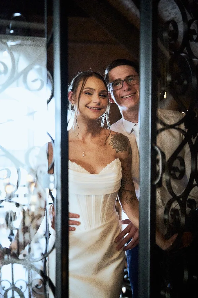 Bride opening ornate iron doors inside the Riviera Waterfront Mansion