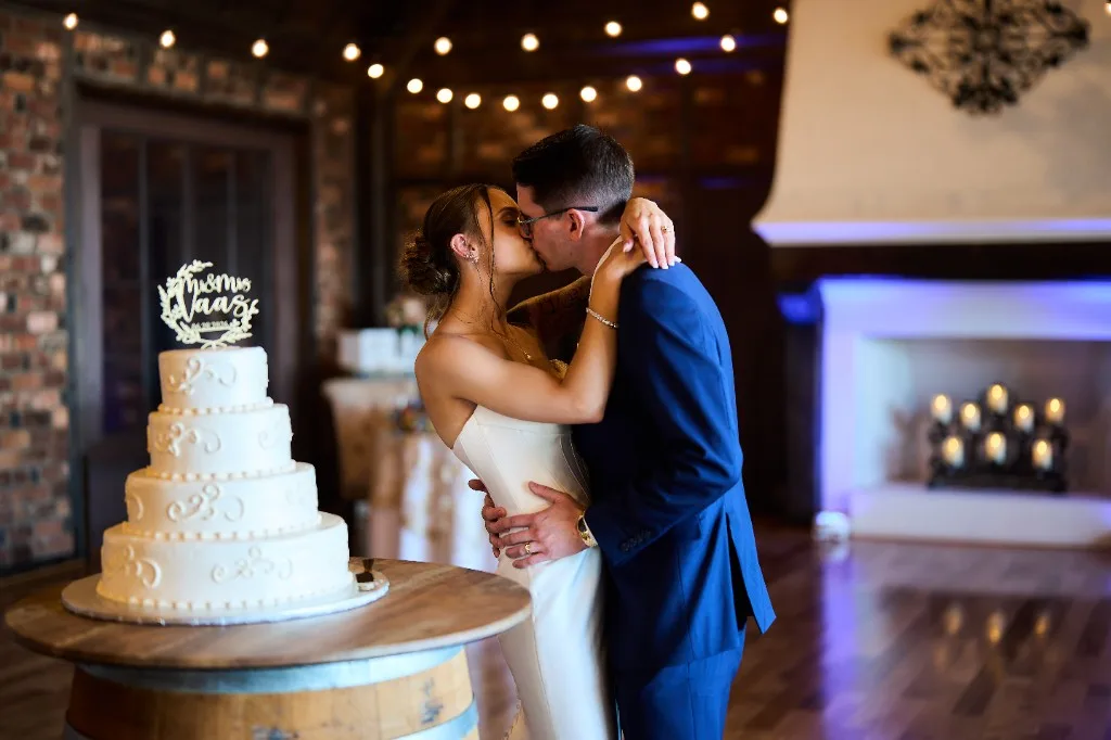 Bride and groom kiss in the ballroom at the Riviera Waterfront Mansion