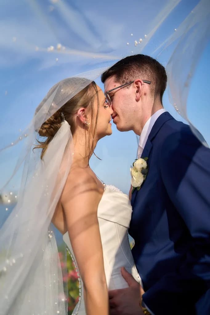 A clear, published price list, Bride and groom kiss in the ballroom at the Riviera Waterfront Mansion