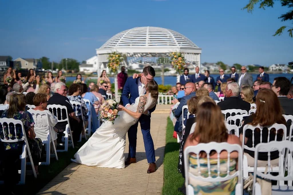 A private first look on the grounds, Bride and groom silhouetted in the reception room windows overlooking the bay at the Riviera