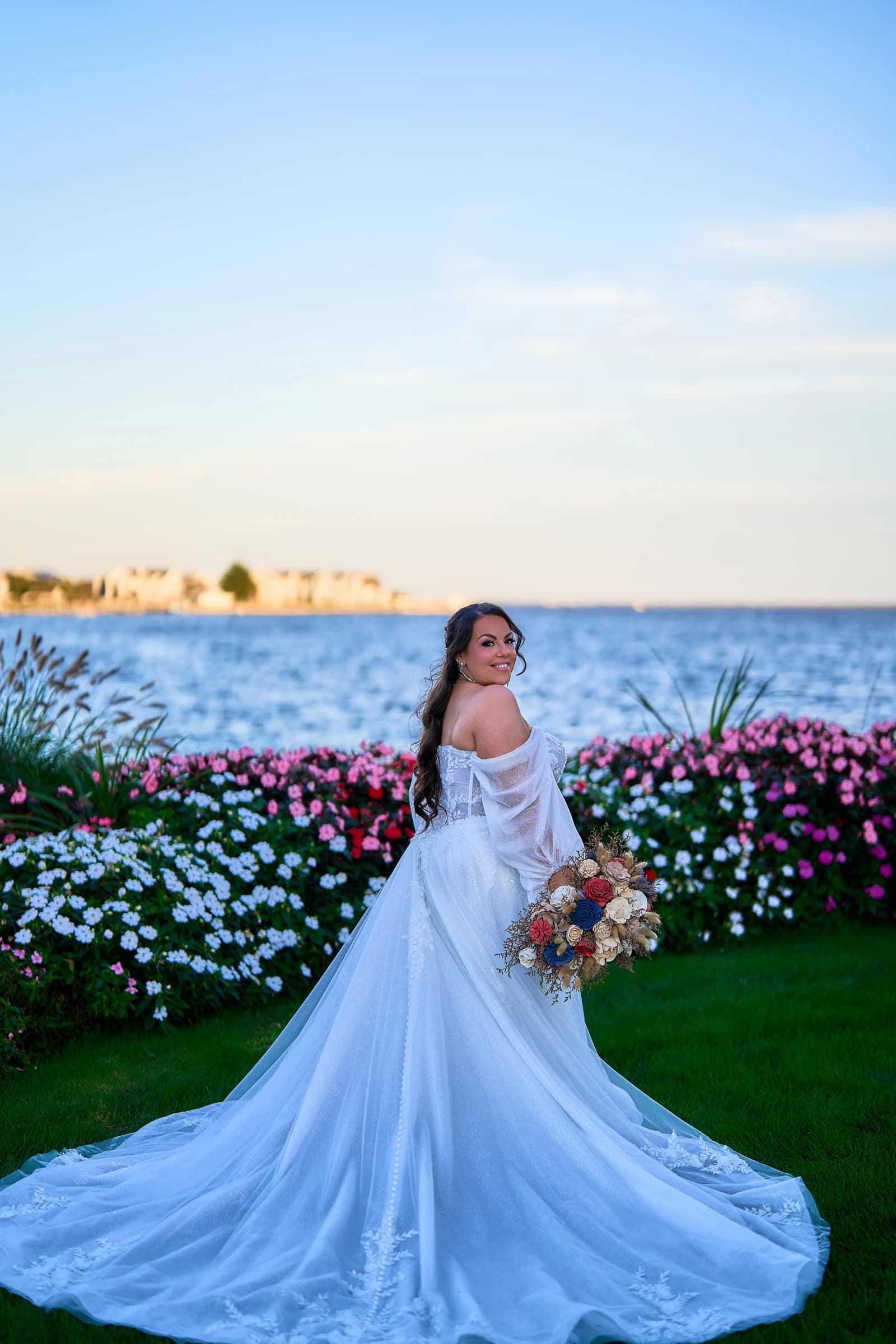 Stephanie looking back on the lawn, the lace train of her gown spread behind her at the Riviera