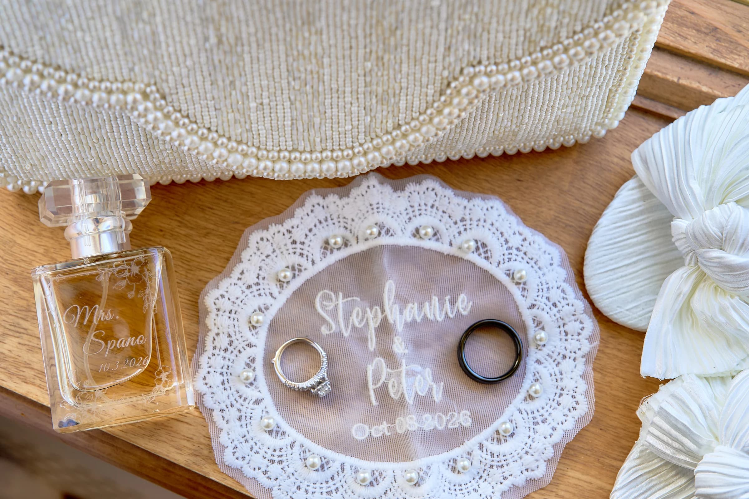 The Garden City Hotel, Garden City, Stephanie and Peter's wedding details, with engraved Mrs. Spano perfume, their rings, and a lace card for October 3, 2026