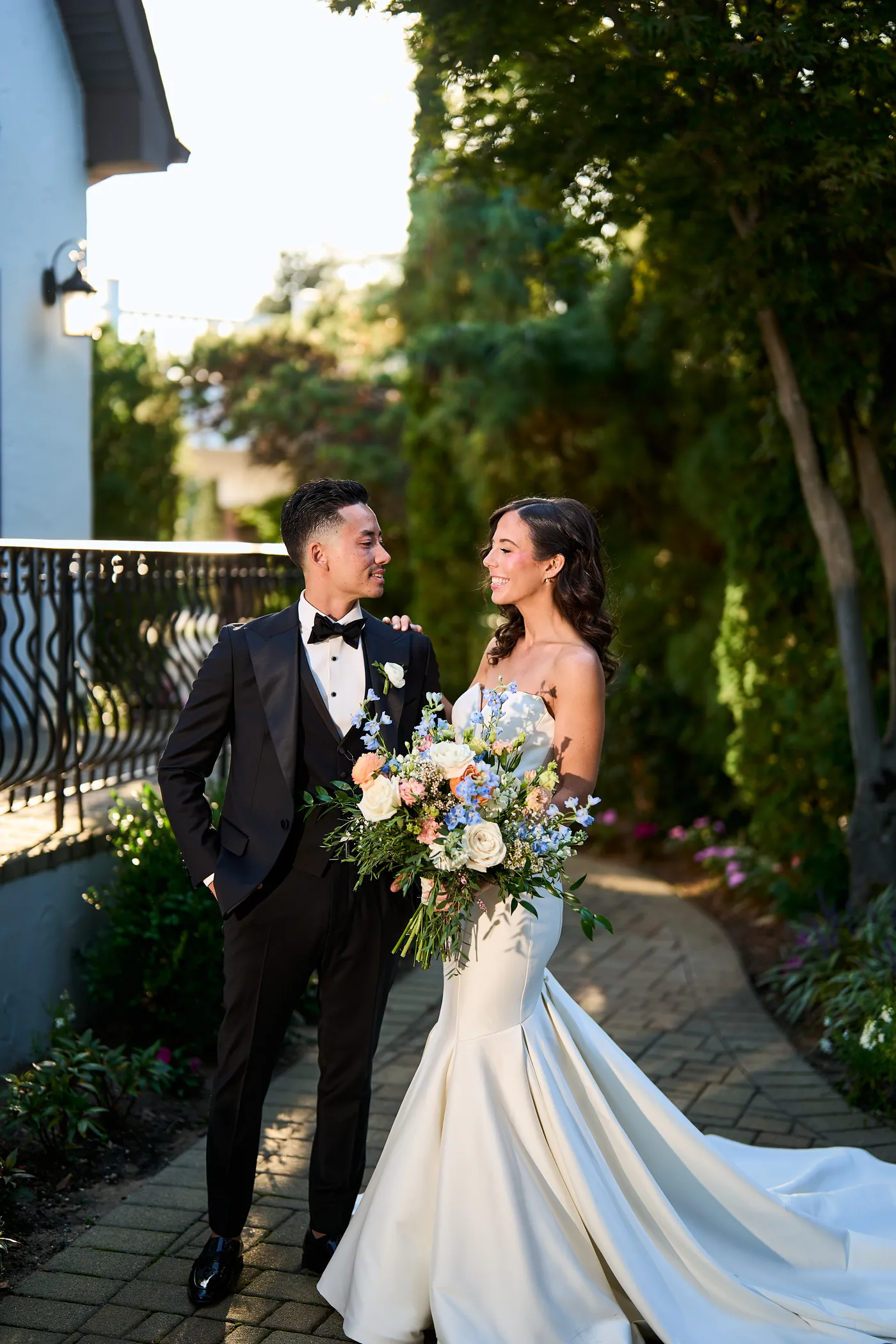 Great Hall against a grand staircase, Bride and groom share a moment in a greenhouse full of plants