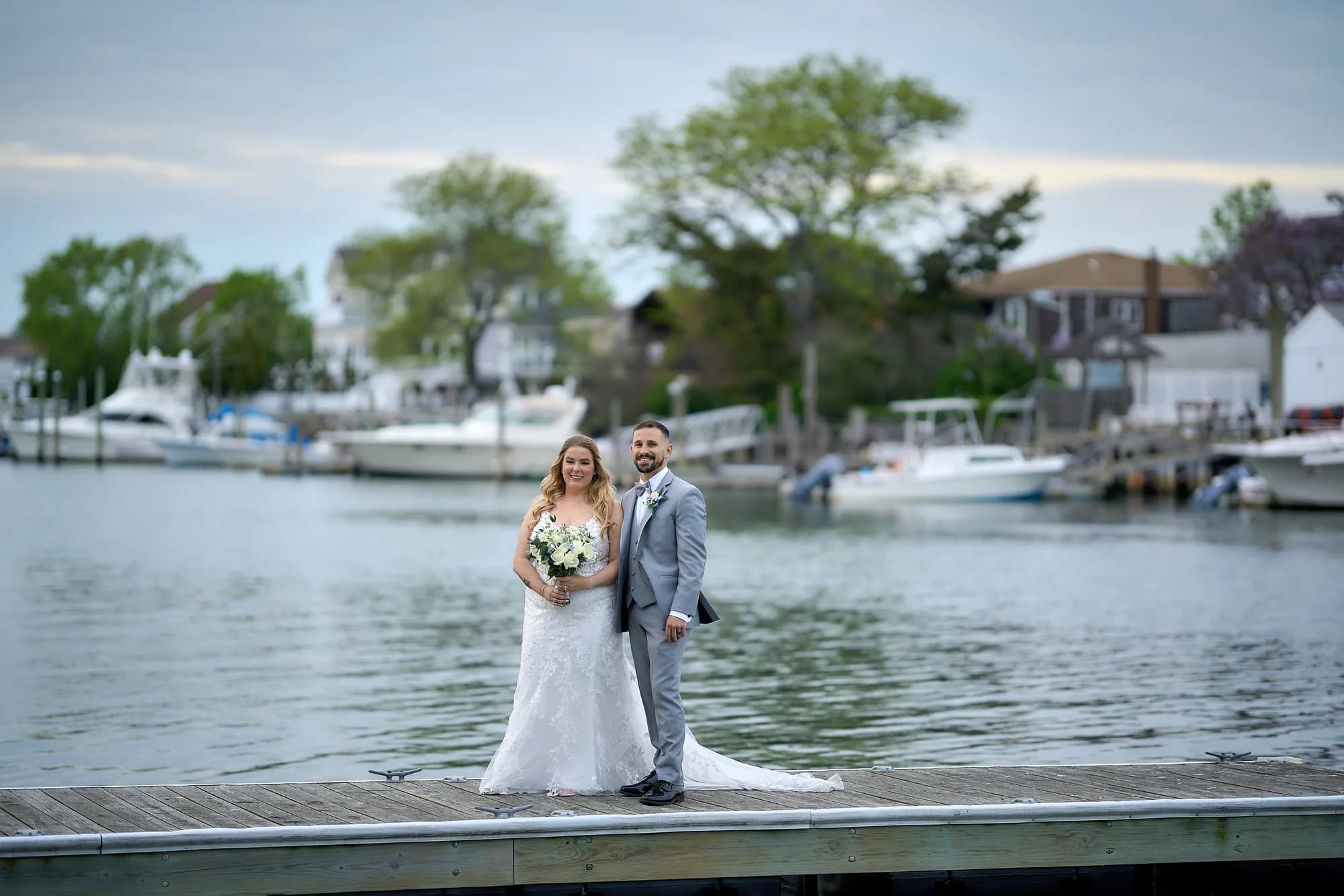 Grand staircase portrait inside the estate, Bride and groom on a dock with boats and a harbor behind them