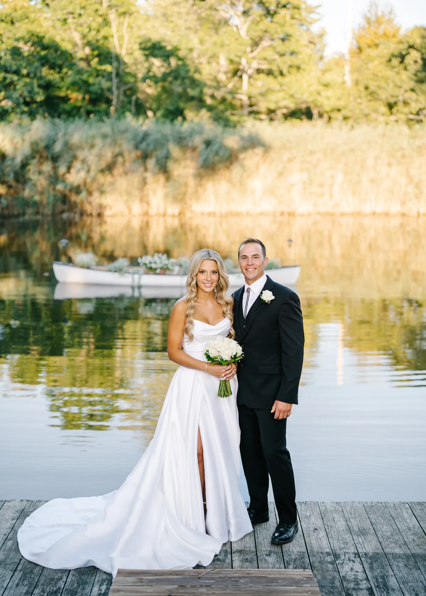 The Coral House, Baldwin, Couple on a waterfront lawn at sunset, the bride in a fitted gown